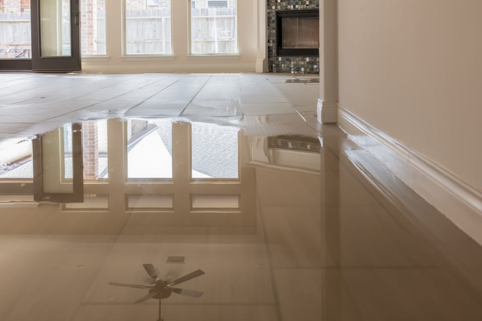 Water damage to hardwood floors and walls in Austin home